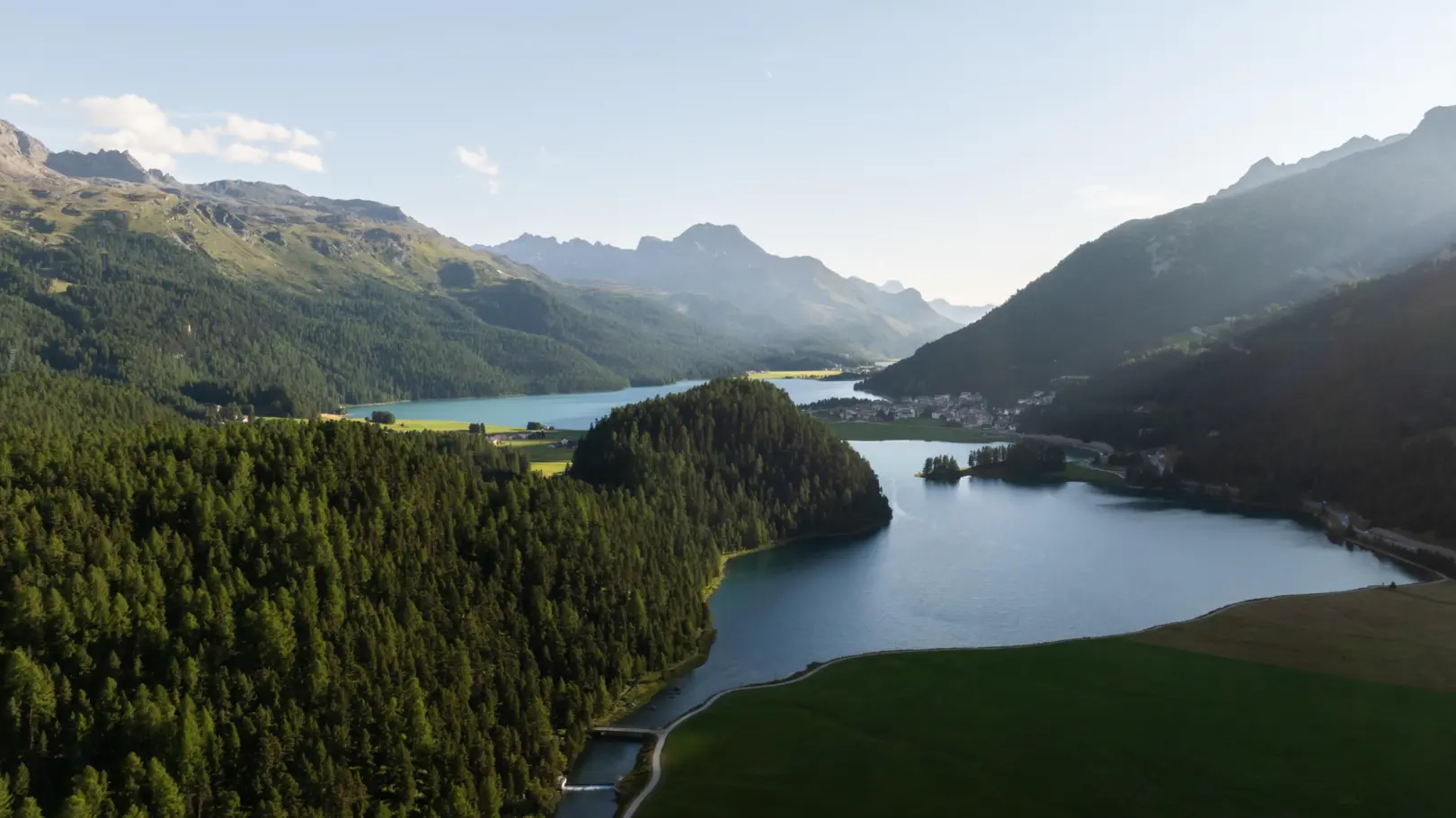 A picture of the Engadin valley with a lake on it.