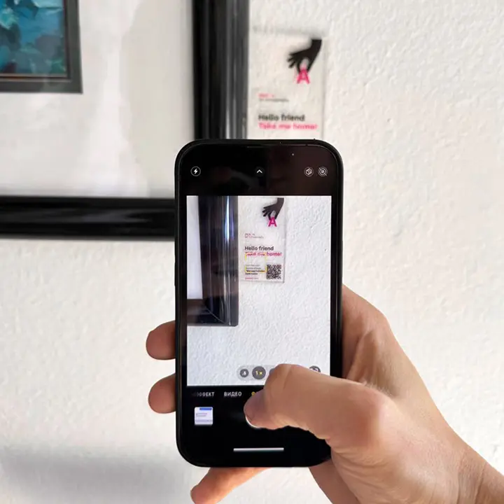 Besucher scannt einen QR-Code neben einem ausgestellten Kunstwerk