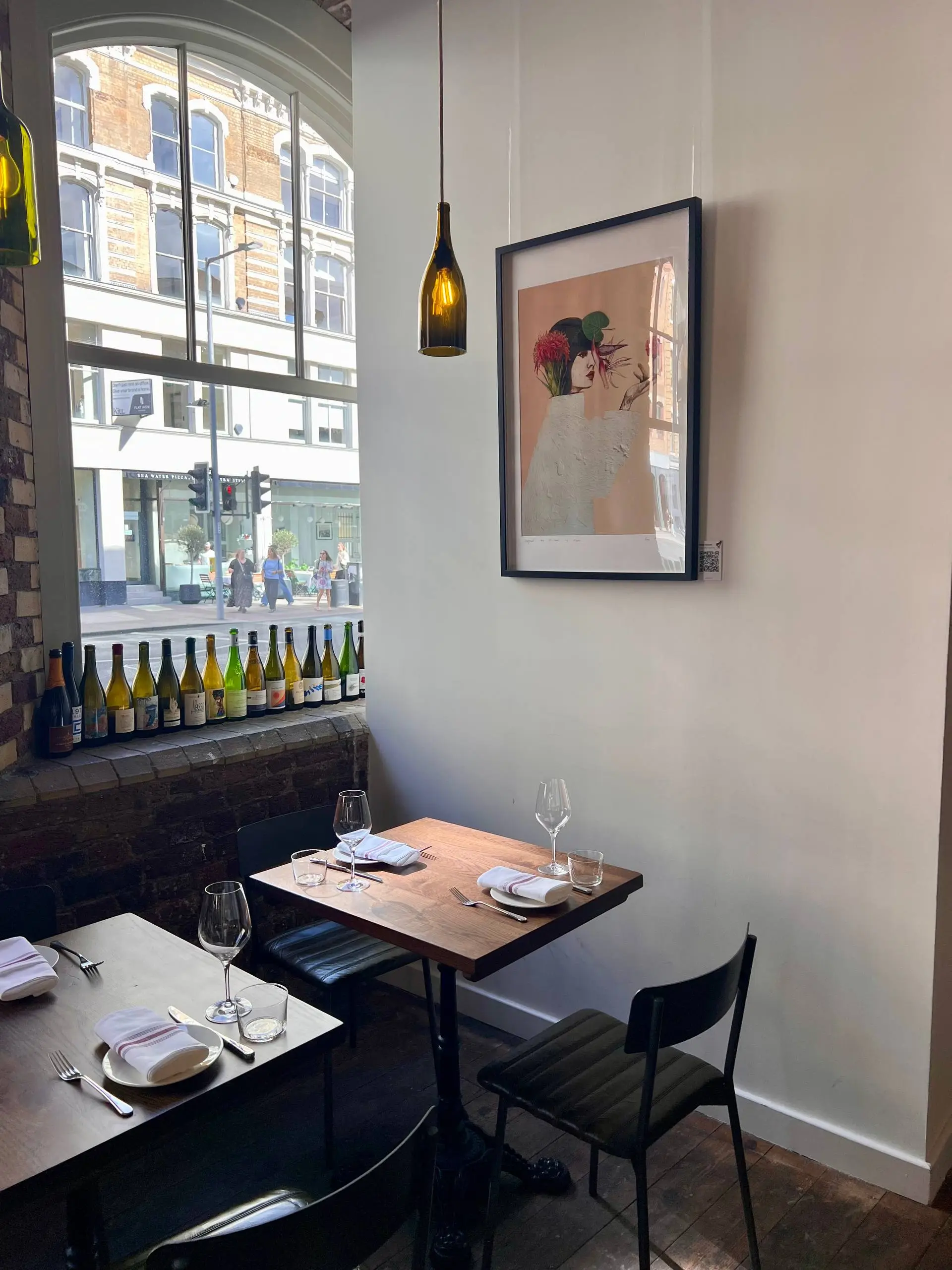 The same wall at Lady of the Grapes with a framed artwork hung from the rail above the table