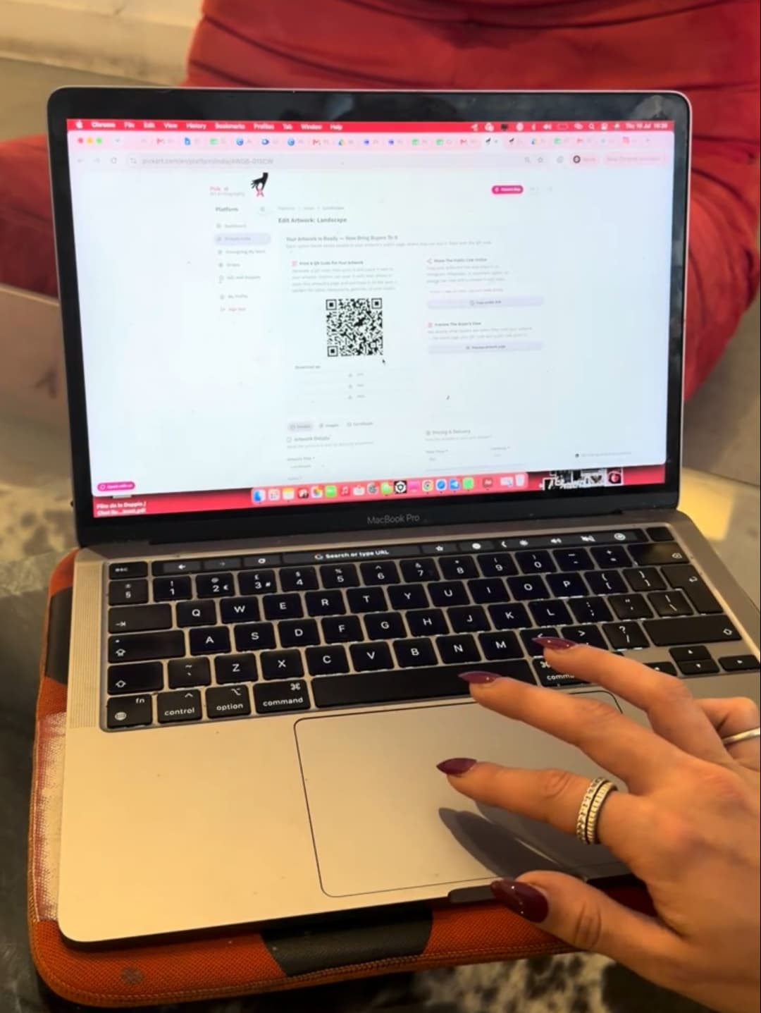 An artist using a laptop to generate a QR code for their artwork on PickArt Indie